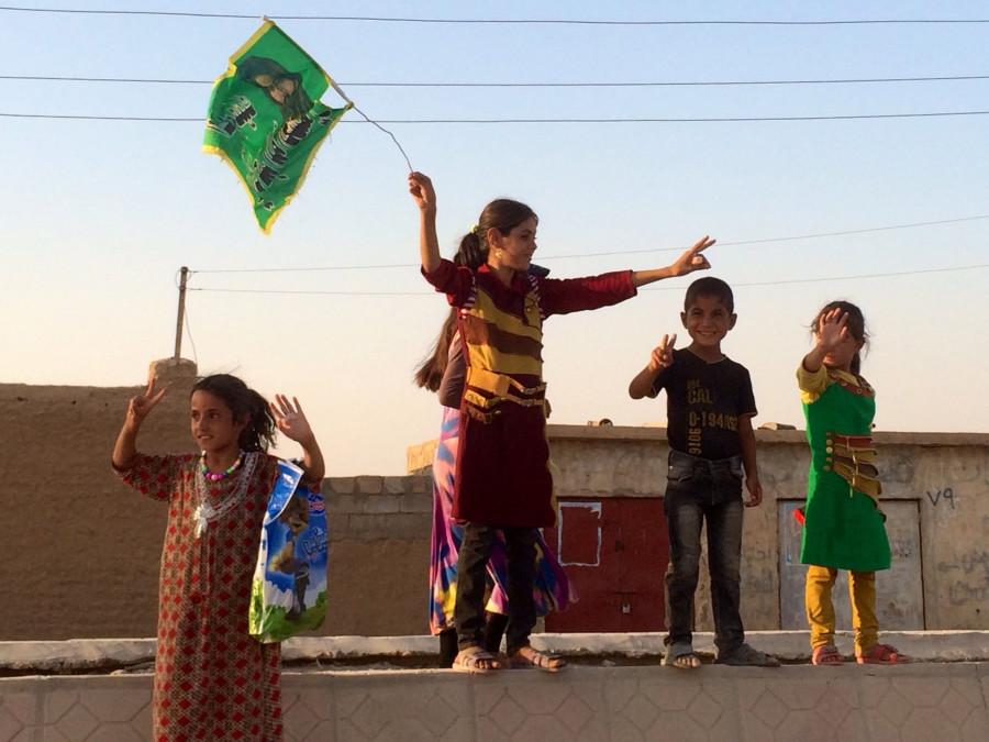 Children greet Shiite militiamen entering Amirli, Iraq, on Monday, Sept. 1, 2014, after Iraqi forces liberated the town from a nearly three-month siege by Islamic State militants.