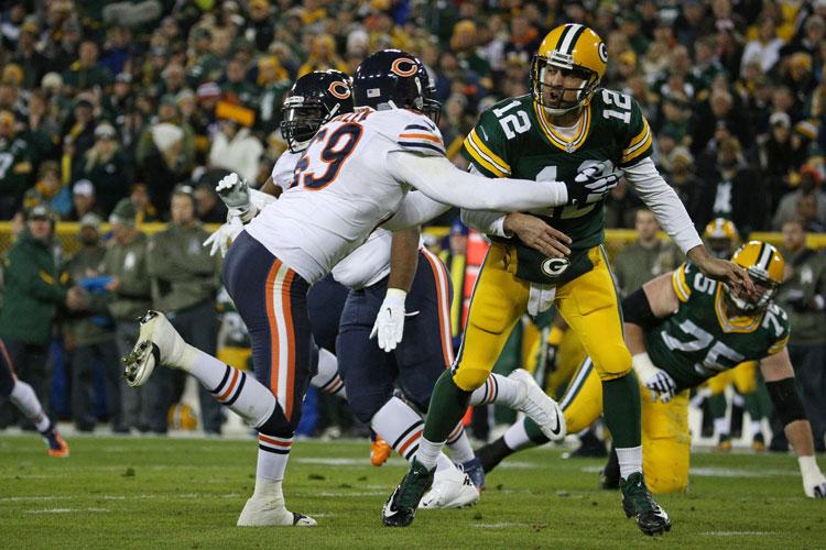 Green Bay Packers quarterback Aaron Rodgers (12) is tackled by Chicago Bears defensive end Jared Allen (69) after making a pass during the first quarter of an NFL football game between the Chicago Bears and the Green Bay Packers, Nov. 9, 2014 at Lambeau Field in Green Bay, Wis.