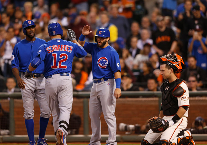The Chicago Cubs Kyle Schwarber (12) celebrates a three-run home run with teammates against the San Francisco Giants as catcher Buster Posey looks on in the third inning at AT&T Park in San Francisco on Tuesday, Aug. 25, 2015