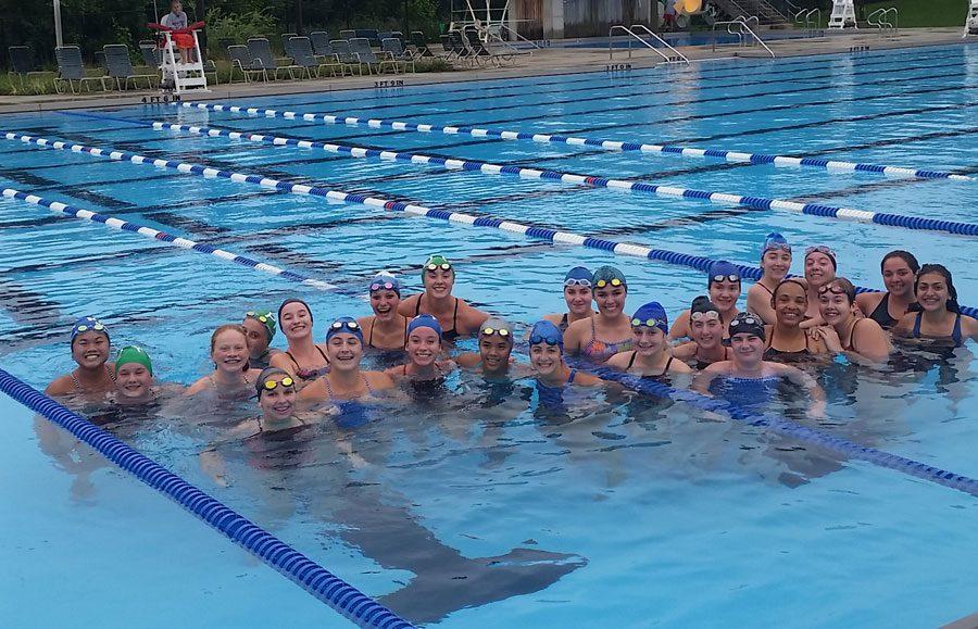 The girls swim team posing at Birchwood pool. One of three pools the teams has practiced at this season.