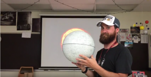 Hoffman Estates science teacher, Tyler Michie displays the earths relationship to the sun during the eclipse. 