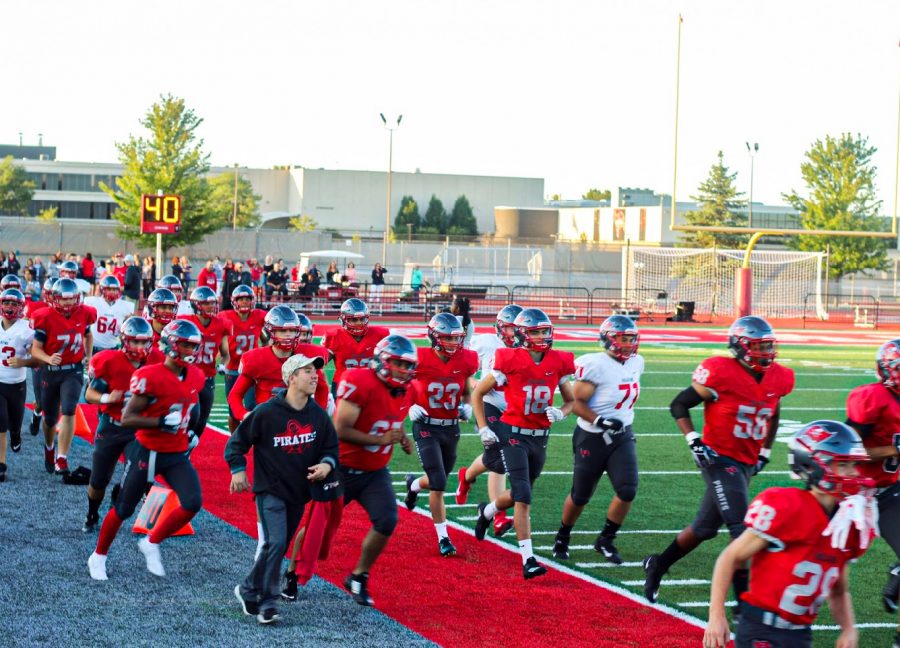 The Pirate football team rushes onto the field.