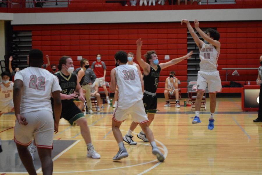  Senior Luke Seiffert #10 shoots for a three-point basket during the game. Seiffert has taken many younger players “under his wing” since the beginning of the season.