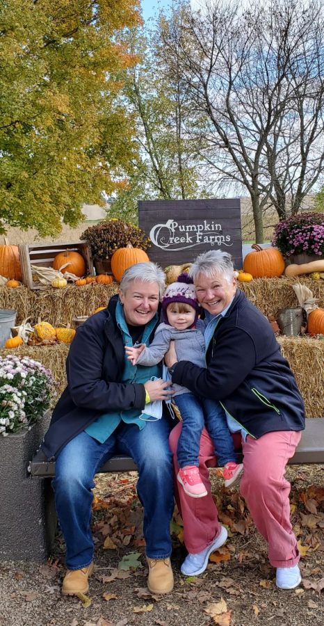 Dawn Shepherd (left) sits with her wife and her granddaughter at Pumpkin Creek Farms in Sherman, IL.