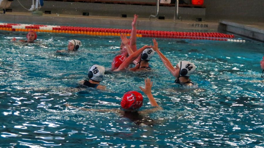 PHS water polo players attempt to secure a goal as they all reach for a ball to be passed.