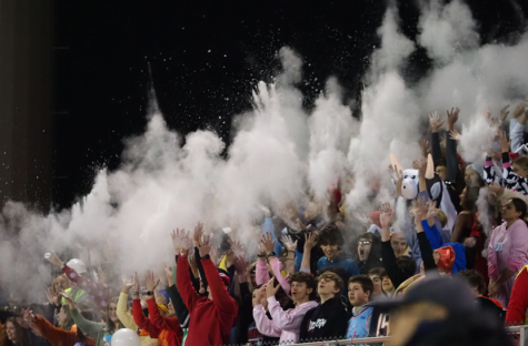 Students celebrate the kick-off of the football game by throwing baby powder in the air. Picture taken at the DGS game.