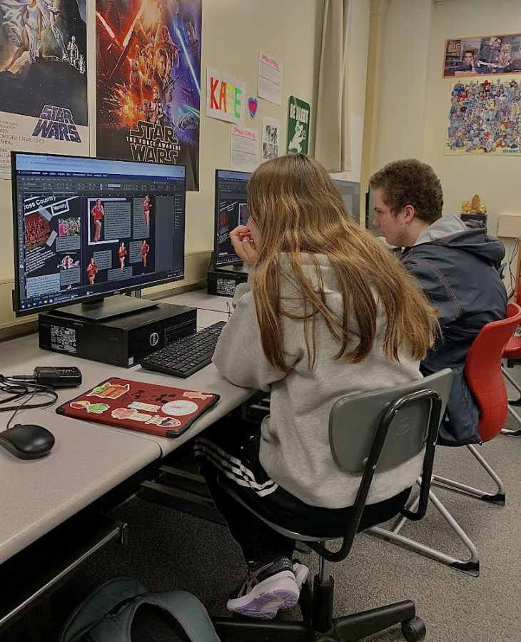 Junior Kate Latek and senior Shawn Adler diligently work on creating their yearbook spreads.