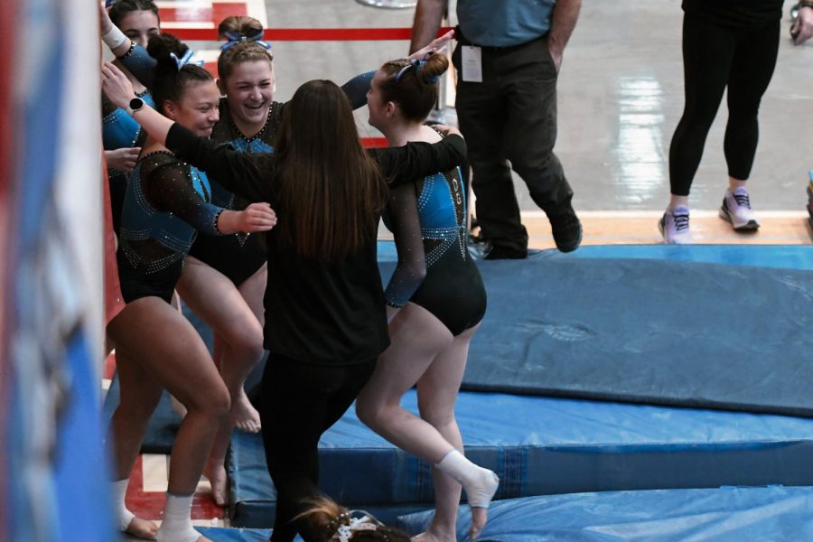The DGHS team celebrates a successful performance for one of their gymnasts. DGHS won first place for all-around team performance.