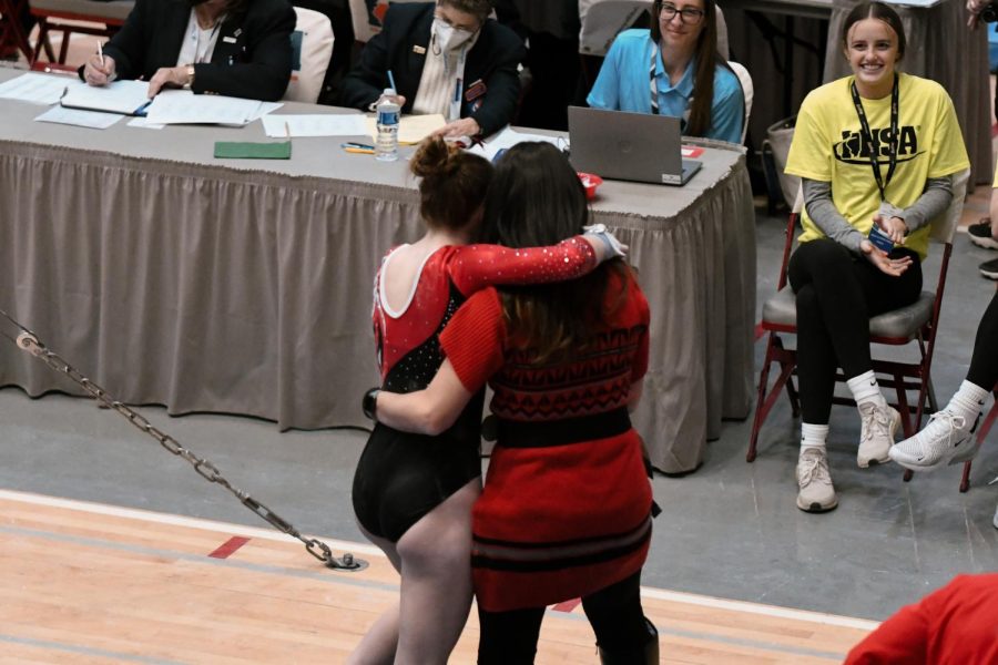 A PHS competitor hugs a coach after a performance in front of IHSA officials and student workers.