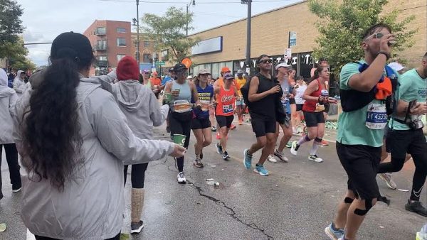 Students from Project Excel hand out cups of Gatorade to runners at the 2023 Chicago Marathon.