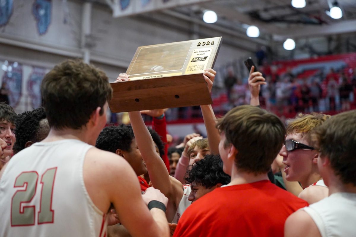The basketball team celebrates their victory as they receive the MSL West trophy.