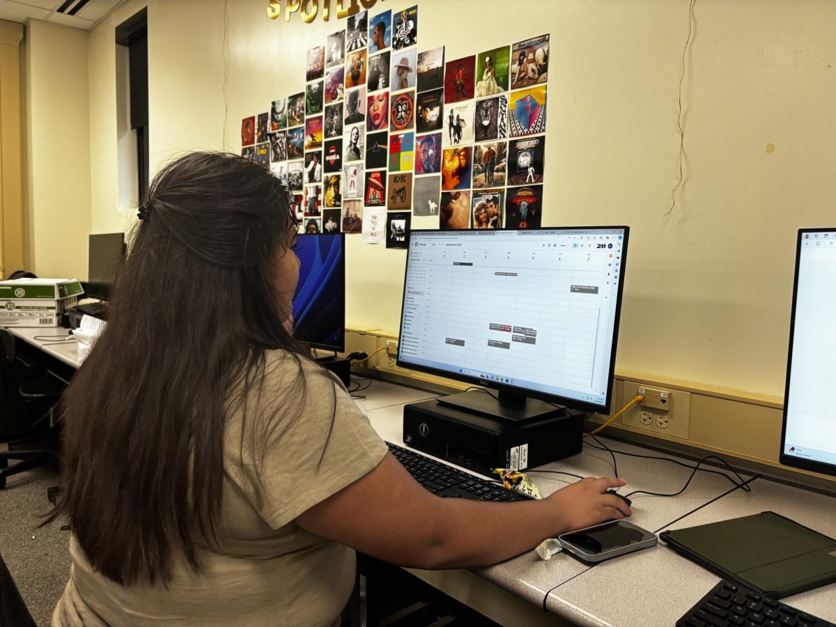 Sports editor Karina Orozco edits her calendar for upcoming sports photos.