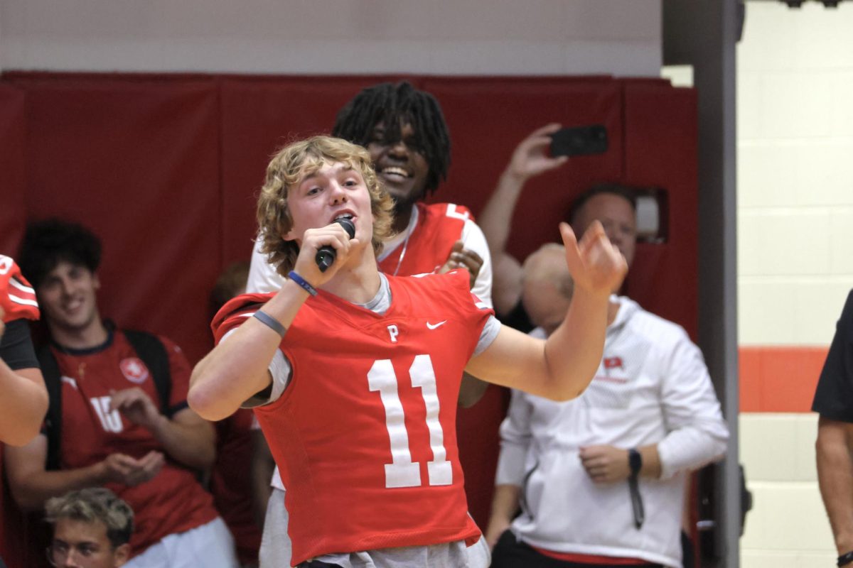 Palatine football's number 11, Trey Widlowski, makes a speech to celebrate the start of football season.