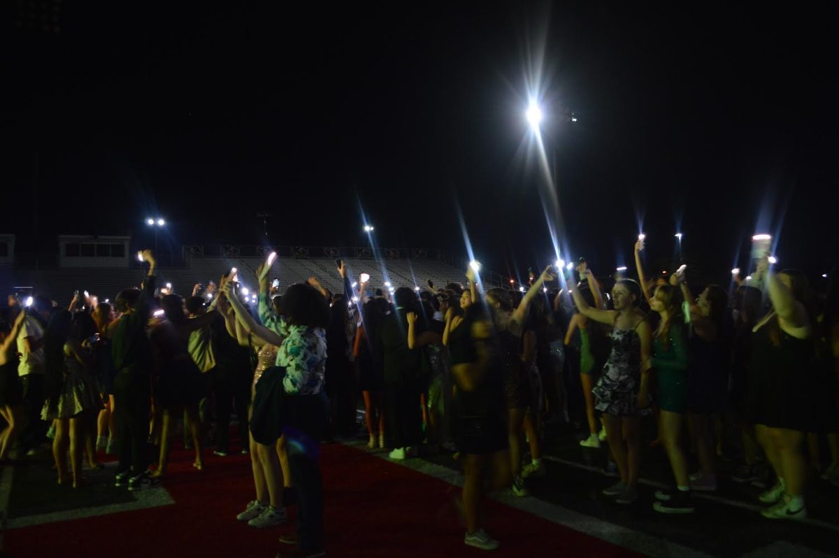 Students shine their phone flashlights to the music at Palatine High School’s 2024 Homecoming dance.