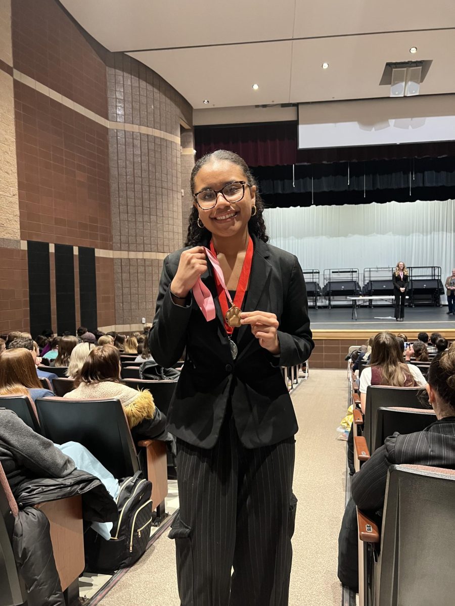 Martinez holds up her 1st place medal in Original Oratory at the Bolingbrook HS Tournament of Dreams.