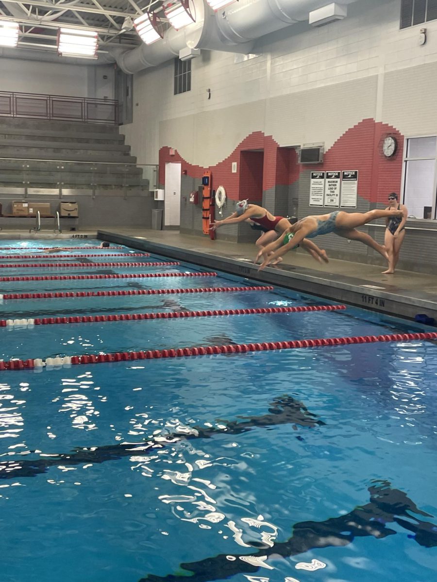 The varsity swim team dives in to complete an aerobic set. 
