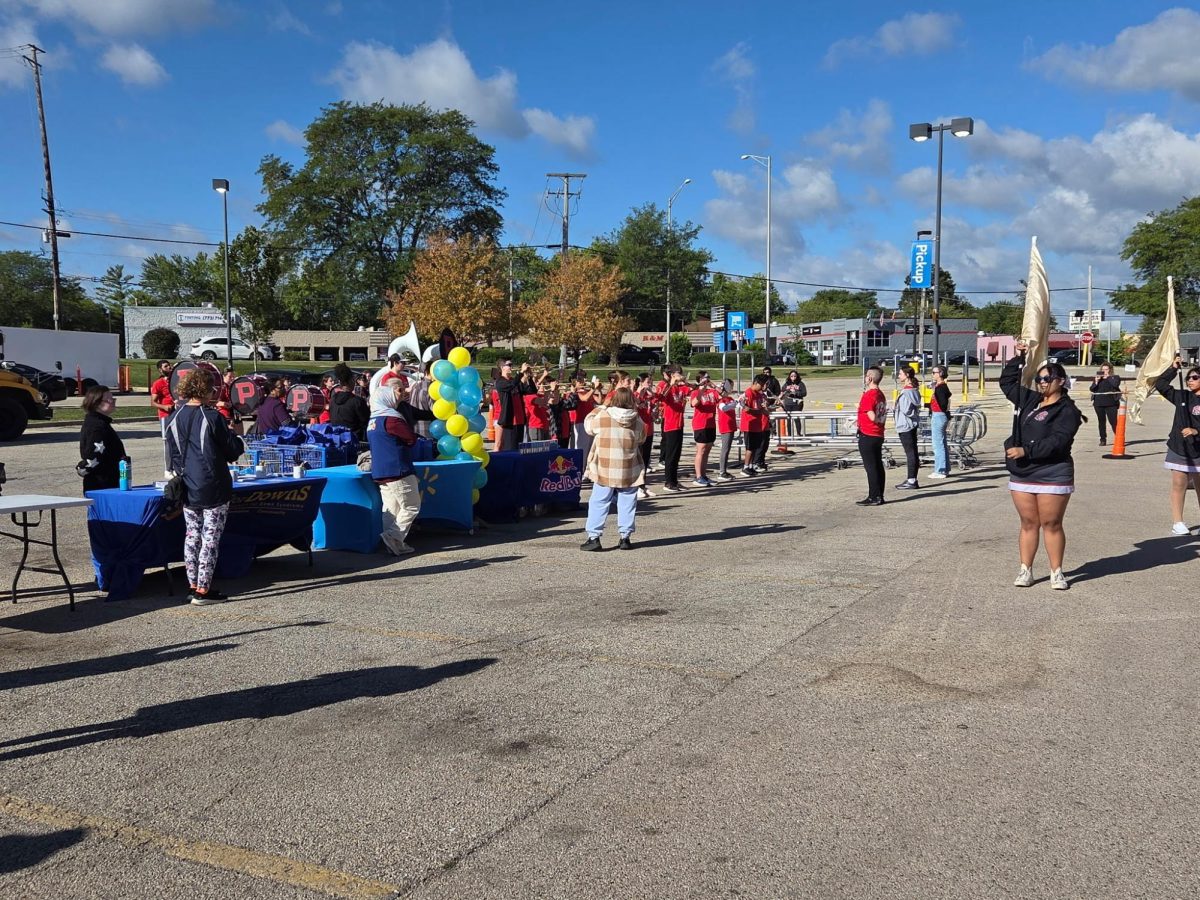 Palatine High School students from band and color guard perform in the parking lot of the Walmart on Rand Rd. 