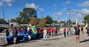 Palatine High School students from band and color guard perform in the parking lot of the Walmart on Rand Rd. 