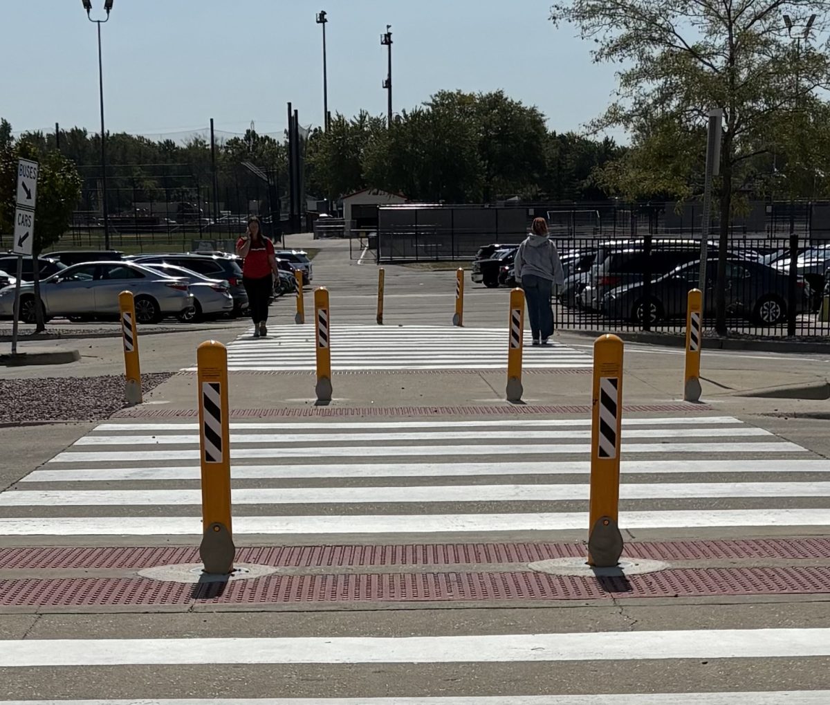 New yellow bollards in between each walkway in the PHS parking lot leading up to the gym entrance of the school building 