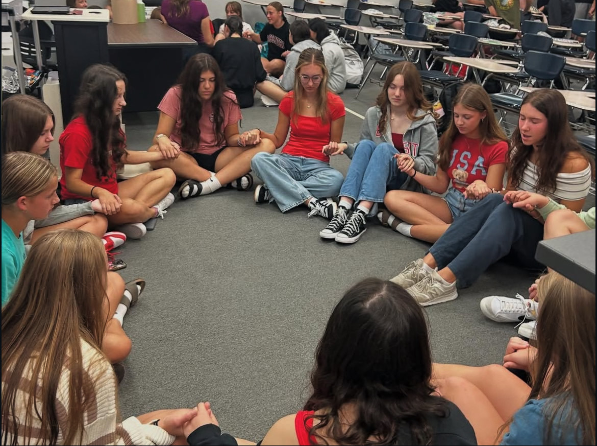 Students gather in prayer at an FCA meeting.