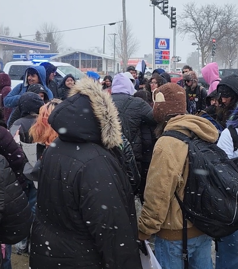 Students from across Township High School District 211 gather at the intersection of Dundee Road and Arlington Heights Road during a district-wide walkout protesting ICE raids