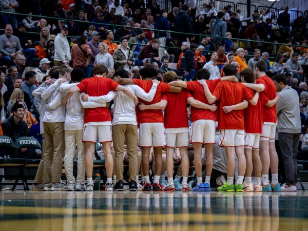 The Varsity Pirates Basketball in a group huddle before the IHSA Sectional Semifinal match against Hersey.