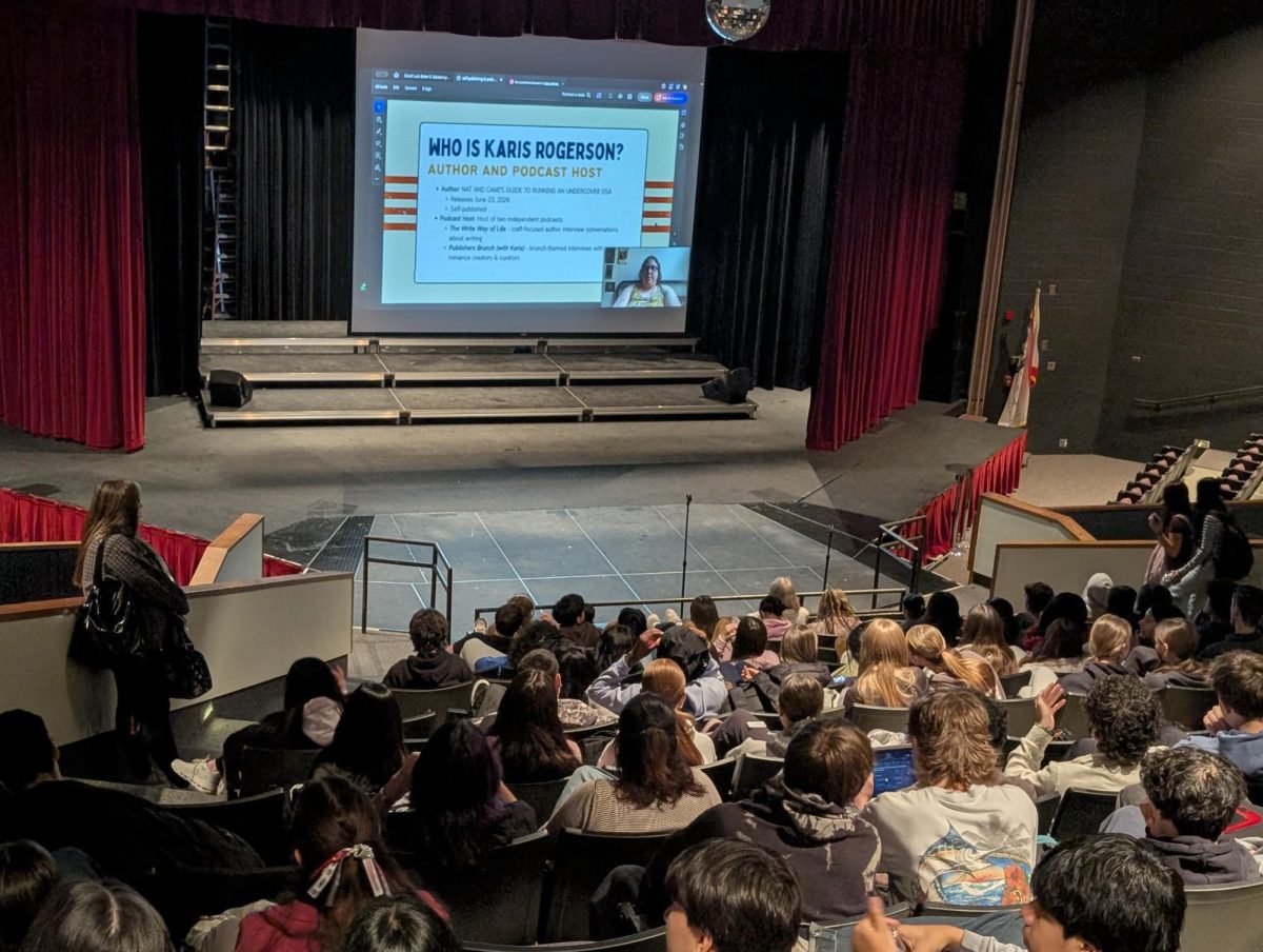 Author and podcaster Karis Rogerson presents via Zoom, sharing her journey and advice on self-publishing and podcasting with a large student audience.